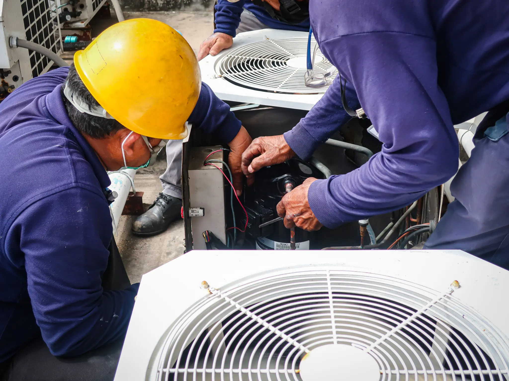 HVAC maintenance team working on an outdoor air conditioning unit